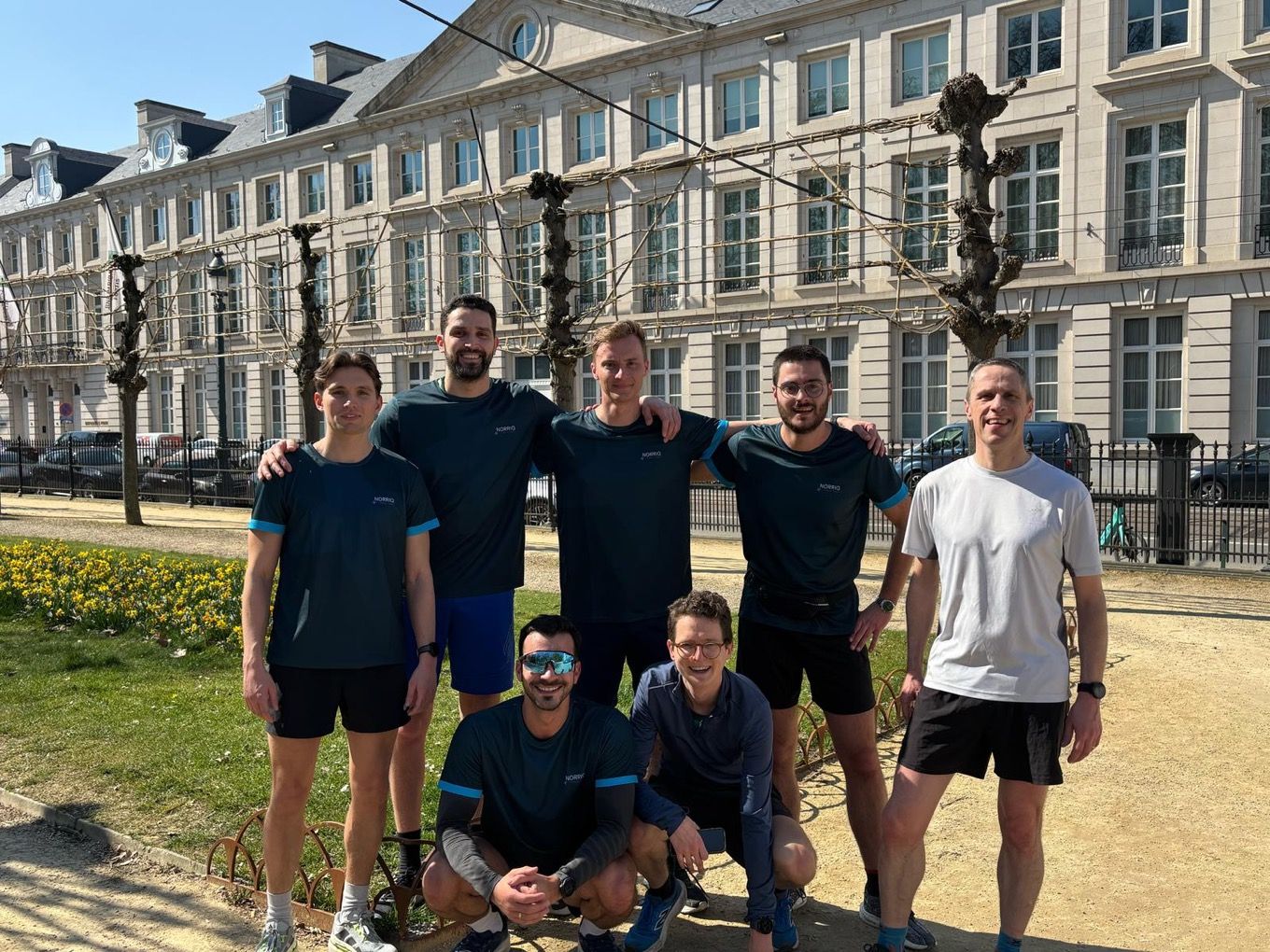 Team of runners posing outdoors in athletic gear