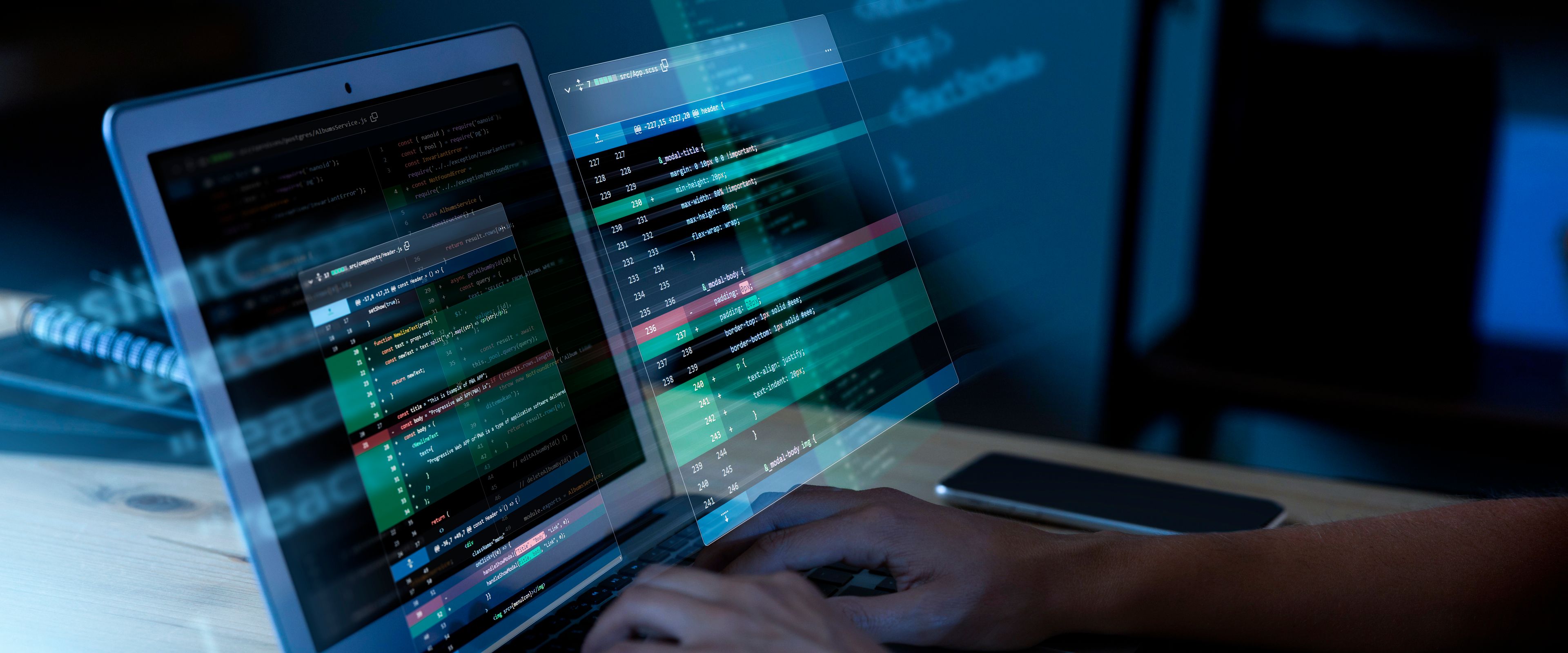 Hands typing code on a laptop with digital interface overlays.